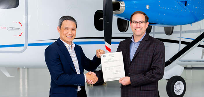 The FAA’s Paul (Vu) Nguyen, acting manager of the Wichita ACO Branch (left) presents type certification of the Cessna SkyCourier to Chris Hearne, Textron Aviation’s senior vice president of engineering